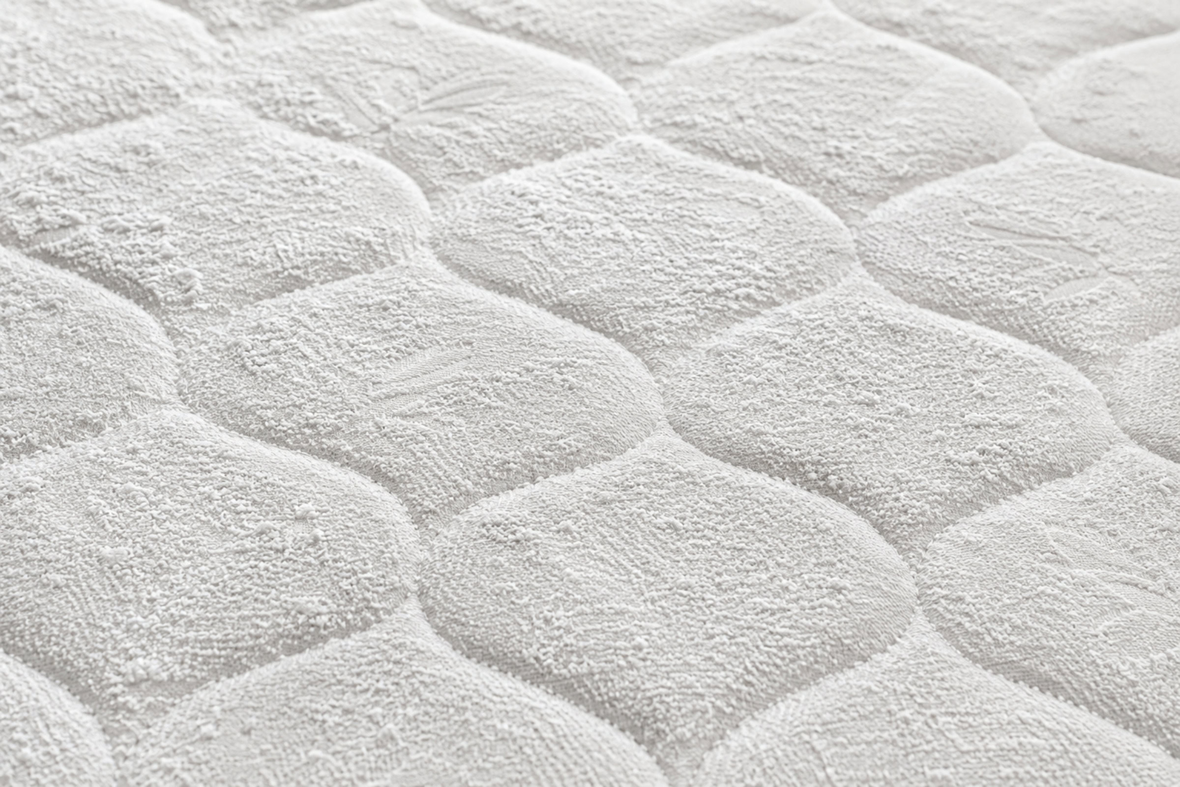 A thin, even layer of baking soda dusted across the top of a mattress